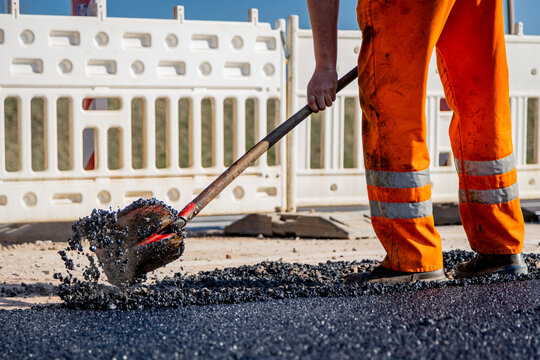 Stra&szlig;enbauarbeiter bei der Arbeit in der Sonne