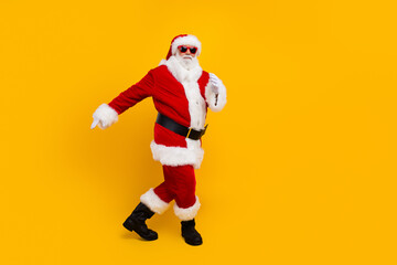 Fototapeta na wymiar Full size photo of overjoyed elderly santa good mood dancing empty space new year occasion isolated on yellow color background