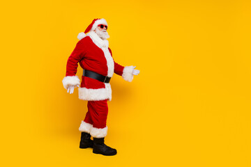 Fototapeta na wymiar Full size profile photo of santa claus walk empty space christmas miracle isolated on yellow color background