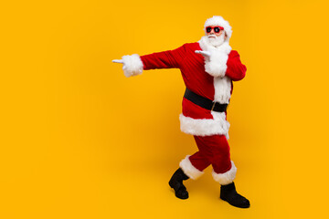 Fototapeta na wymiar Full length photo of excited carefree aged santa dance empty space new year party isolated on yellow color background