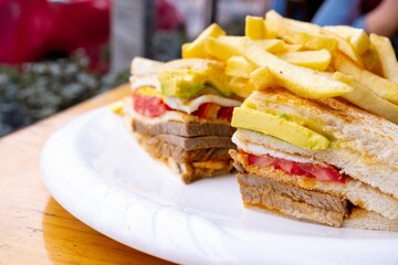 a sandwich and fries with french fries on a white plate