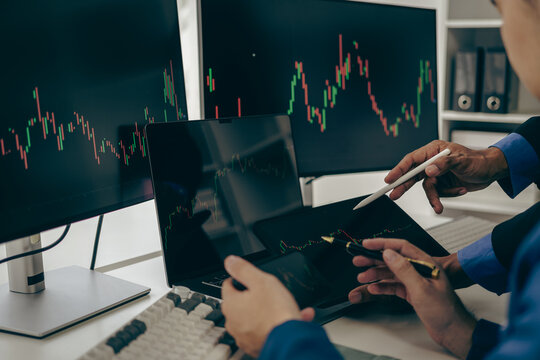 Stock trader looking at stock market chart on screen, analyzing investment strategy, finance working with monitor screen with stock charts and indicators, people working hard to make risk decisions