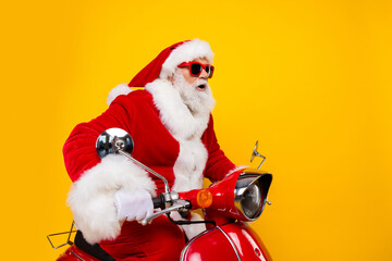 Portrait of funny santa claus ride moped fast speed traveling around world delivery christmas courier isolated on yellow color background