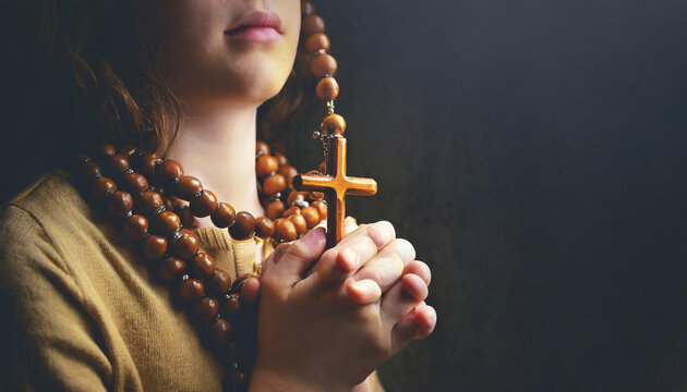 praying hands holding a rosary close up holding necklace with cross pray for god in the dark religious christian symbol with copy space background god and spiritual concepts