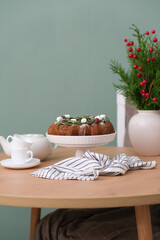 Christmas home interior-Christmas chocolate bundt cake with fresh berries and rosemary. Winter baking at Christmas or New Year with decorations. Ceramic vase with spruce branches.