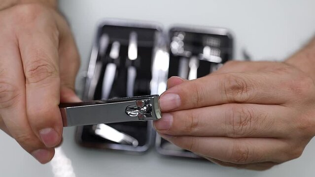 Cutting nails with nail clippers. Men's manicure at home.