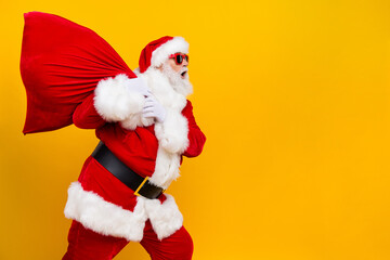 Fototapeta na wymiar Photo of santa claus holiday carry big red christmas bag wear festive costume tired look empty space isolated on yellow color background