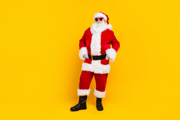 Fototapeta na wymiar Full body photo of charismatic granddad santa put arms waist empty space new year adv isolated on yellow color background