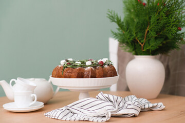 Christmas chocolate bundt cake with fresh berries and rosemary. Winter baking at Christmas or New Year with decorations. Ceramic vase with spruce branches.