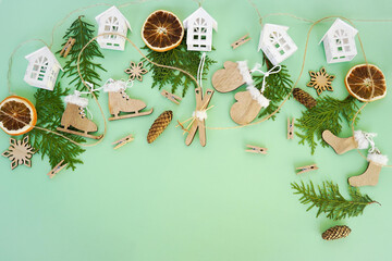 Wooden Christmas toys, thuja branches and dried orange slices on a green background. Christmas...