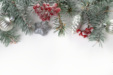 Christmas card with fir branches, viburnum berries covered with hoarfrost, and Christmas decorations. Copy space