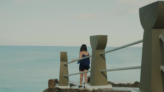 Girl walking at Taga beach while sightseeing, slow motion
