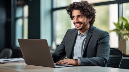 Smiling Adult Indian Man with Brown Curly Hair Photo. Portrait of Business Person in the office in front of laptop. Photorealistic Ai Generated Horizontal Illustration.