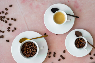 three cups with espresso and coffee beans