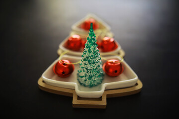 Christmas background. Dish in the shape of a Christmas tree with balls decorations on the table.