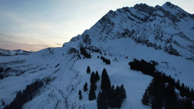 Scenic drone landscape with sunset behind the snowy mountain 