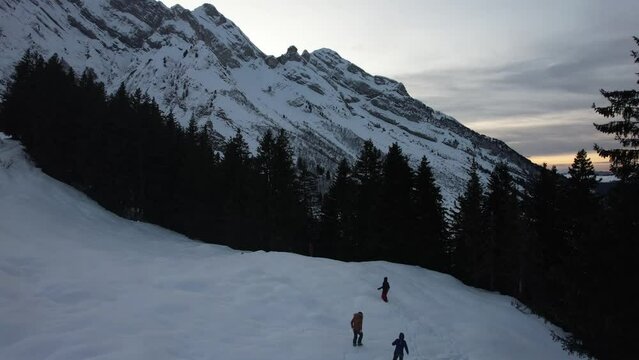 Hiking at sunset in the snow with alpine trees