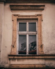window of a building with peeling paint and wooden frame with brown wooden frame