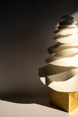 a christmas tree with white papers and gold paper with a light shining on it