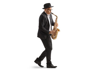 Full length profile shot of a mature male musician playing a sax