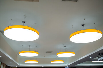 Round chandelier on the ceiling of warm light, lighting with LED lamps, interior design, office...