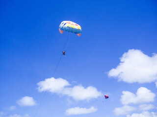 Parasailing is an activity of flying alone using a parachute at a height of 70 meters, pulled by a speedboat into the middle of the sea