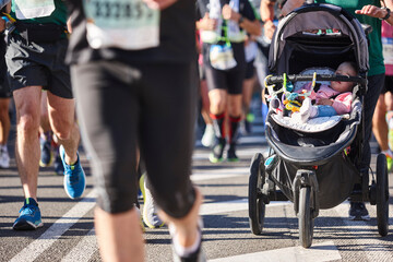 Runners and baby on the street. Healthy lifestyle. Marathon. Athletics