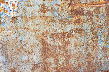 Background and texture of an old painted sheet of metal with rust showing through and paint peeling off.