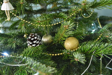 Obraz na płótnie Canvas Gold decoration toys and cone on the fir-tree