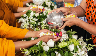 Songkran is thai tradition(thai new year).juniors pour water on the hands of revered elders and ask...
