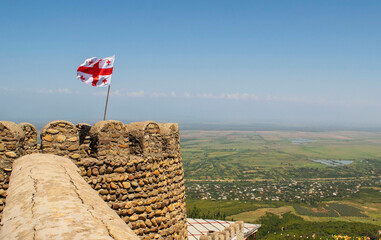 Sighnagli, Georgia. Overview of Kakheti wine producing province from Signagi Wall. Georgian flag is waving on a wall tower
