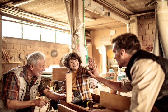Three Generations of Carpenters : Grandfather, Father, and Son working in the Workshop