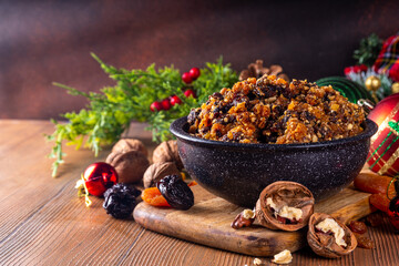 Homemade Christmas sweet mincemeat bowl, dried fruit mince meat for traditional winter mince pies with cinnamon sticks, anise, with festive decorations and christmas tree branches