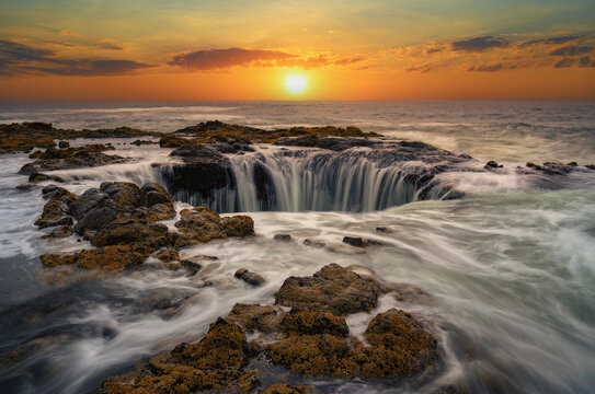 Water rushes into Thor's Well in Pacific Ocean at sunset in Oregon. © Nick Fox