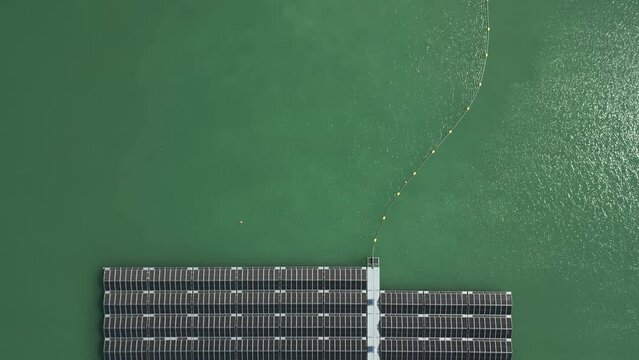 Luftaufnahme eines Fluges über schwimmende Solarpaneele eines Solarparks auf dem Wasser eines Sees