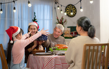 Happy Asian family celebrating Christmas at home. with the activity of giving gifts to each other...