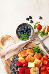 Delicious pancakes with blueberry, strawberry and raspberry. Sweet and tasty breakfast on ligt background