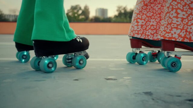 Females rollerblading with wheels sparkling during moves
