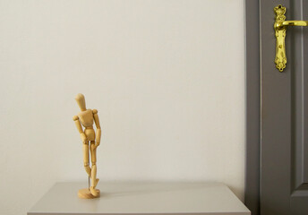 Figurine of wooden man on gray background.