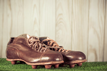 Vintage old outdated soccer or football leather boots with cleats (studs). Retro style filtered...