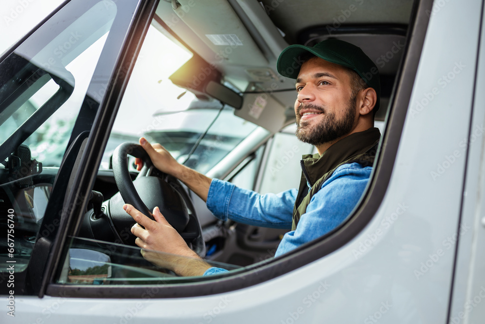 Wall mural Young handsome man working in towing service and driving his truck.