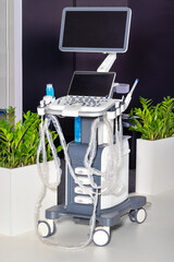 Ultrasound diagnostic system, portable ultrasound scanner on a background of green indoor plants. - 667756768