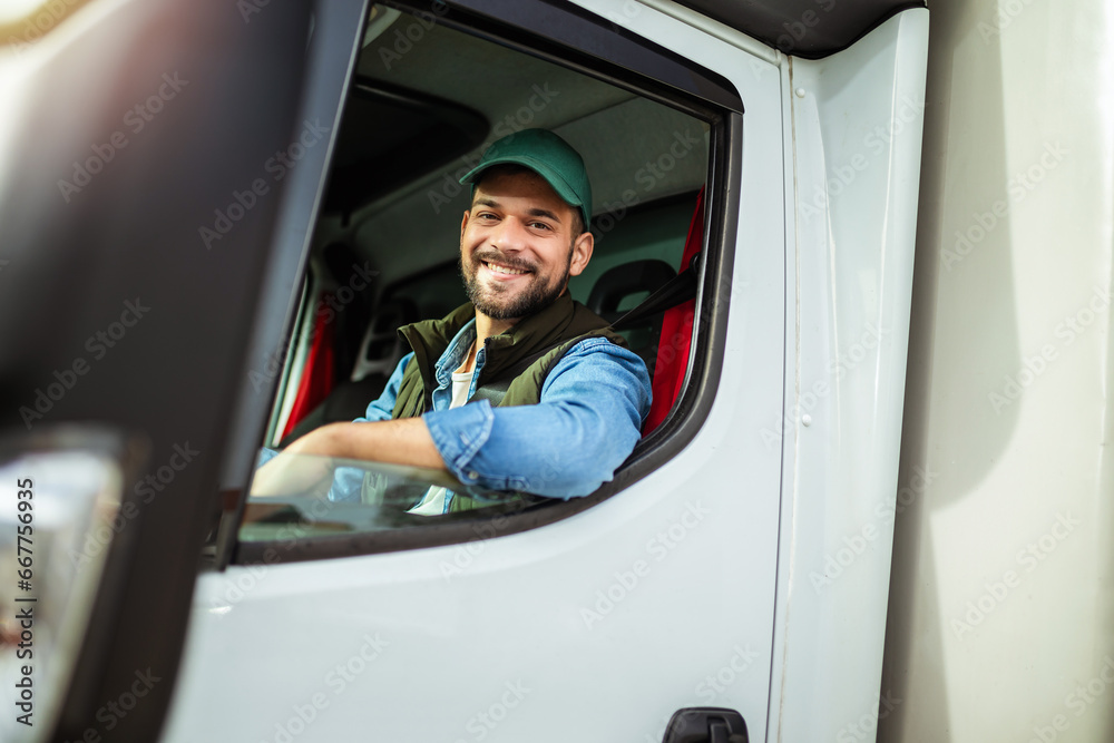 Wall mural Young handsome man working in towing service and driving his truck.