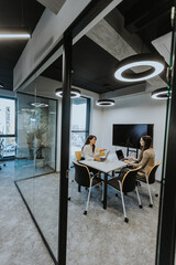 Young business women discussing in cubicle at the office