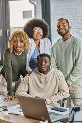 group of cheerful young friends posing together and smiling happily at camera, coworking concept