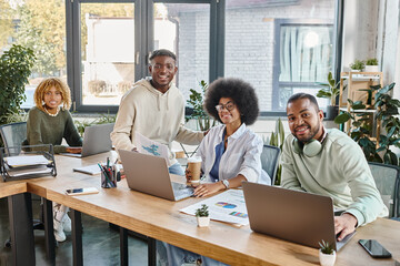 cheerful good looking friends in casual urban attires smiling happily at camera, coworking concept