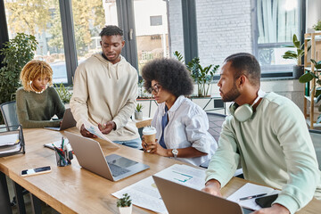 concentrated young people working hard together with laptops and paperwork, business concept