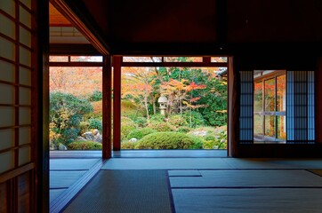 Autumn scenery of colorful maple foliage in a beautiful Japanese garden thru the sliding screen doors ( Shoji ) of a tatami room in Genkoan, a Buddhist temple famous for its Zen garden in Kyoto Japan