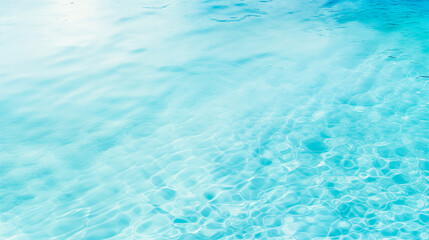 light blue rippled water surface with a slight wave pattern. The water is clear and reflecting the sunlight and has a slight sparkle. Water background.