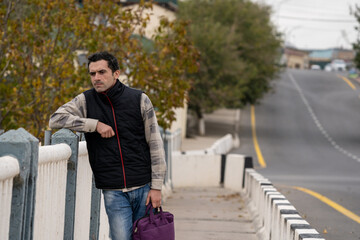 Armenian man, different emotional face actions, in the outdoor, the cold temperature, with the jacket, the man with the suitcase thinking so much